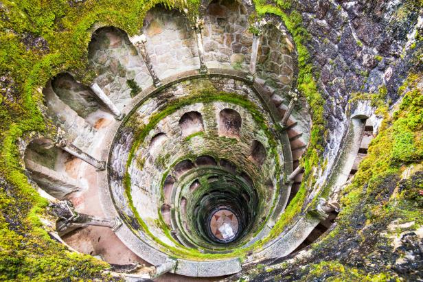 Blick von oben in den moosbewachsenen Initiationsbrunnen Quinta da Regaleira in Portugal.