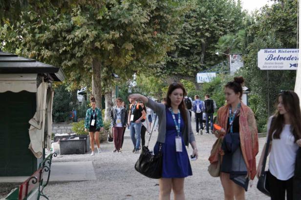 Eine Gruppe junger Leute geht auf einem Weg entlang, möglicherweise auf dem Gelände eines Hotels.