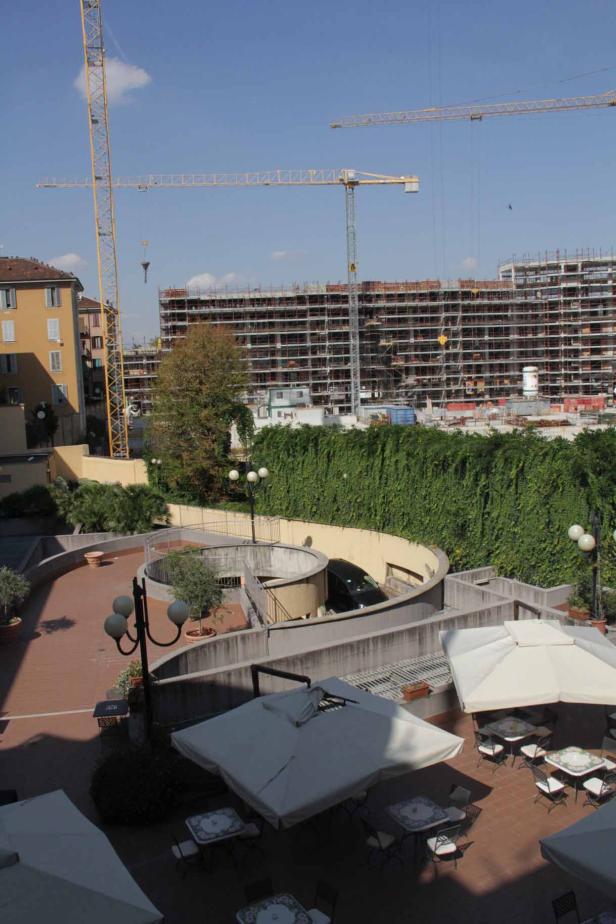Blick auf eine Baustelle mit mehreren Kränen und einem im Bau befindlichen Gebäude.