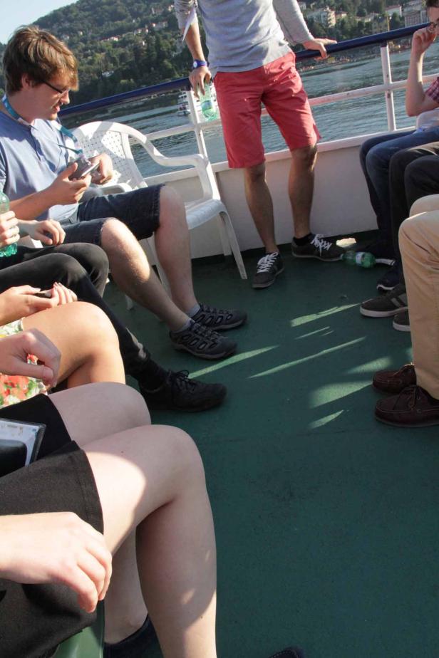 Eine Gruppe von Menschen sitzt und steht auf einem Schiff.