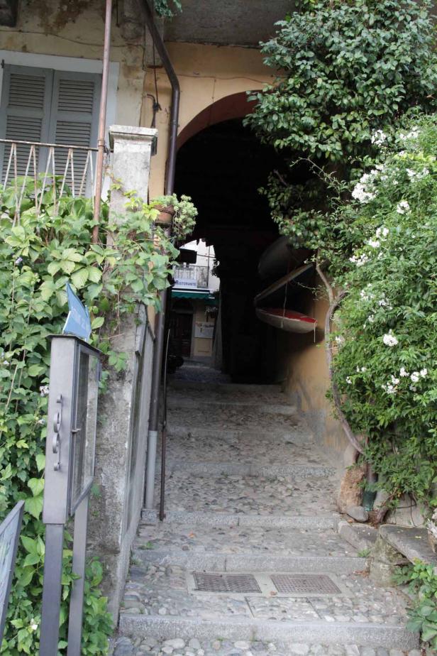 Eine steile Steintreppe führt durch einen dunklen Torbogen hindurch.