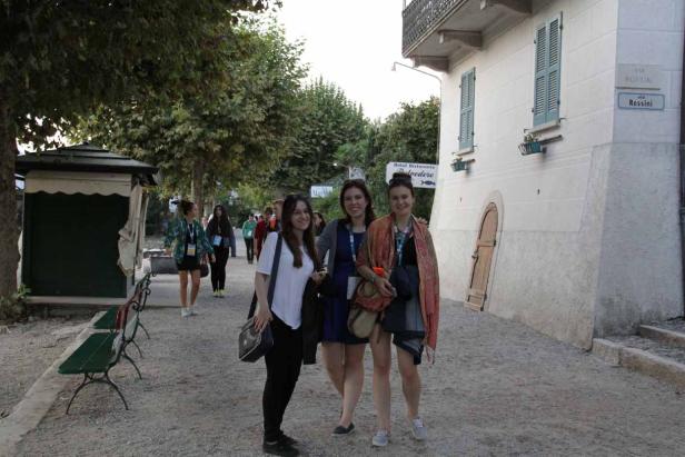 Drei junge Frauen posieren auf einem Kiesweg für ein Foto.