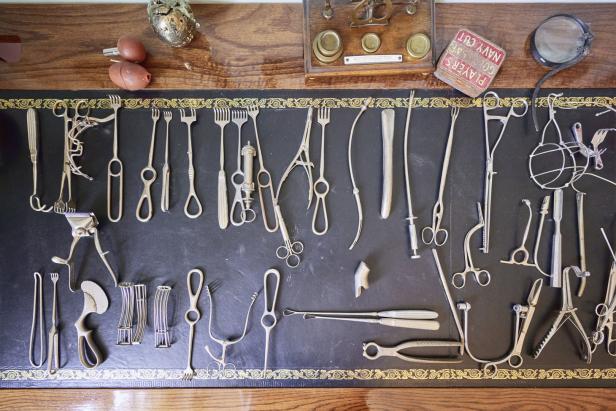 Eine Sammlung von chirurgischen Instrumenten auf einer dunklen Oberfläche.
