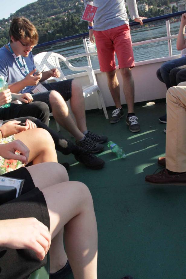 Eine Gruppe von Menschen sitzt und steht auf einem Schiff.