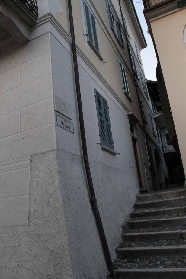 Eine Gasse mit einer Treppe und dem Straßenschild „Via Rossini“.