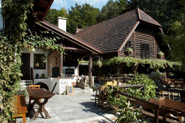Ein traditionelles Holzhaus mit einem einladenden Außenbereich mit Tischen und Stühlen.