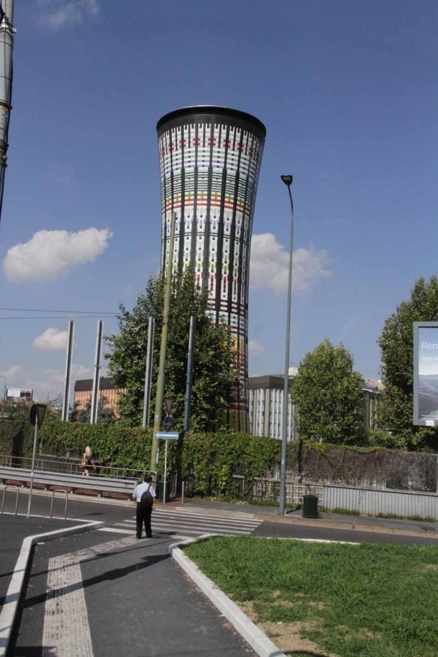 Ein Mann überquert eine Straße vor dem Torre Arcobaleno in Mailand.