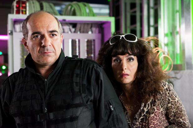 Ein Mann in taktischer Kleidung und eine Frau mit Sonnenbrille auf dem Kopf stehen nebeneinander.