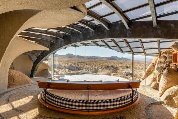 Ein rundes Bett in einem Haus mit Panoramablick auf die Wüste.