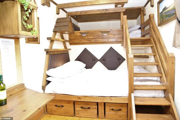 Ein Holzbett mit Stauraum und einer Treppe zum oberen Bett.