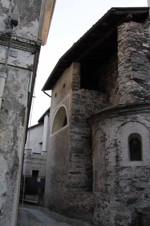 Eine Gasse zwischen alten Steingebäuden mit einem kleinen Fenster.