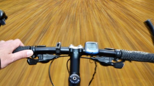 Eine Person fährt mit einem Fahrrad auf einer Straße.