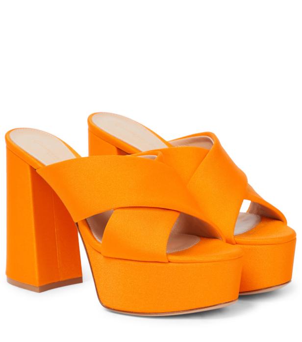 Ein Paar orangefarbene Plateau-Sandalen mit hohem Blockabsatz.