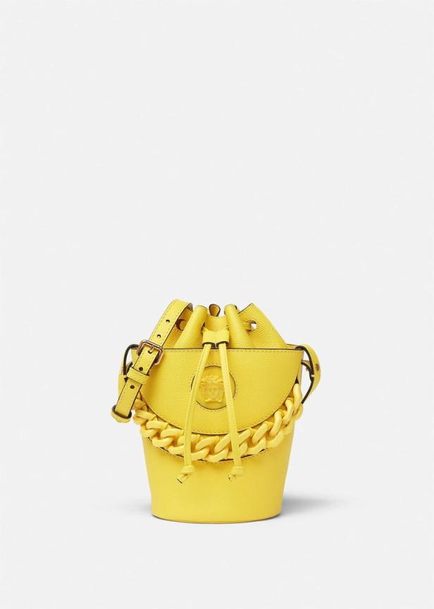 Eine gelbe Handtasche in Eimerform mit einer dicken Kette und einem Trageriemen.