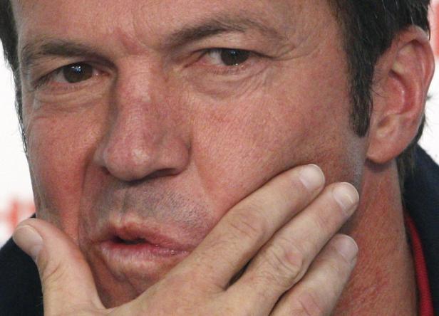 Nahaufnahme eines Mannes, der seine Hand an sein Gesicht hält.