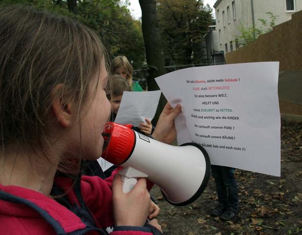 Ein Kind spricht durch ein Megaphon bei einer Demonstration für den Schutz von Bäumen.