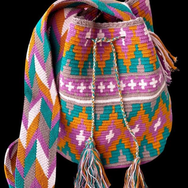 Eine bunte, gehäkelte Umhängetasche mit Quasten und einem geometrischen Muster.
