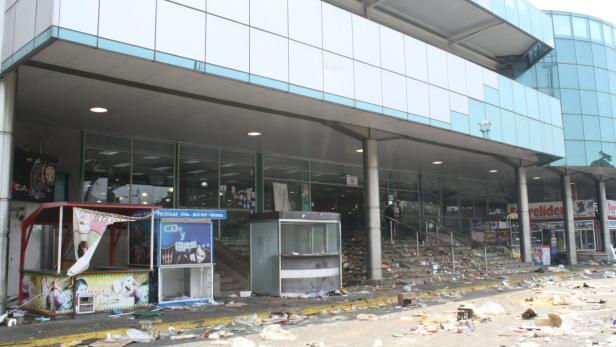 Vor einem Gebäude liegen Trümmer und Müll.