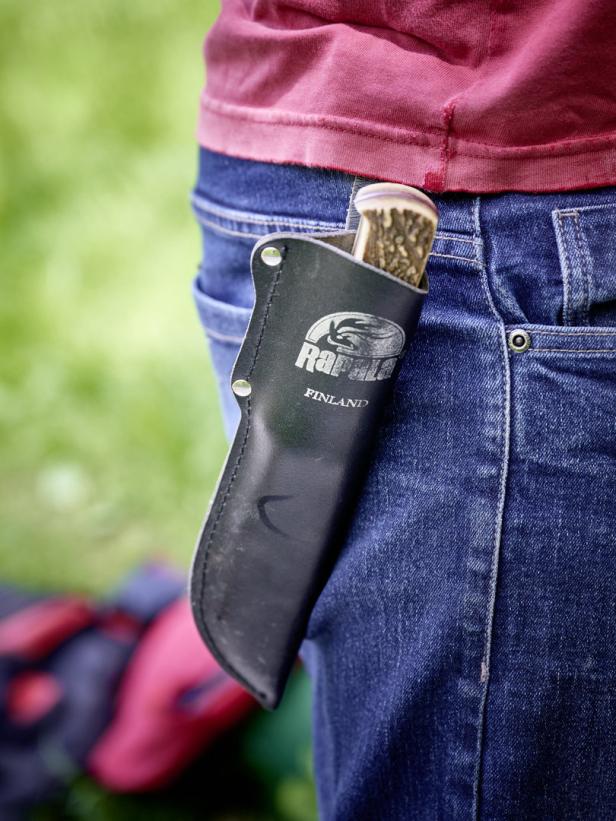 Ein Mann trägt ein Messer der Marke Rapala in einer Scheide am Gürtel.