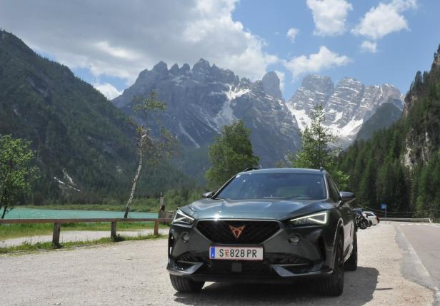 Ein grüner Cupra steht vor einer Bergkulisse mit einem türkisfarbenen See.