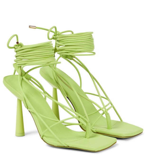 Ein Paar hellgrüne Sandalen mit Absatz und Schnürung.