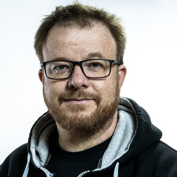 Ein Mann mit Brille und Bart blickt in die Kamera.