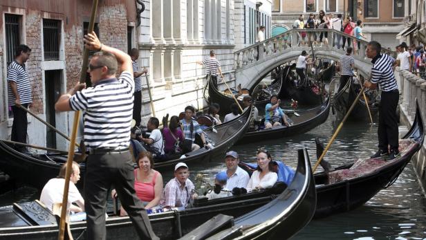 Gondeln gleiten auf einem Kanal in Venedig entlang.