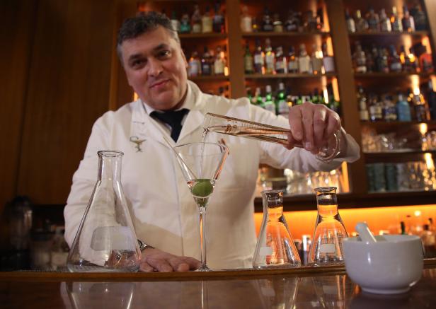Heinz Kaiser mixt einen Drink mit Messzylinder und Laborgläsern.