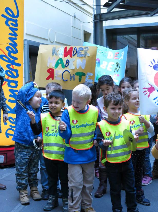 Eine Gruppe Kinder demonstriert mit Musikinstrumenten und Schildern für ihre Rechte.