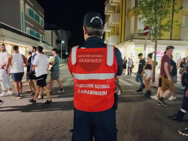 Ein Mitglied der Associazione Nazionale Carabinieri steht auf einer belebten Straße.