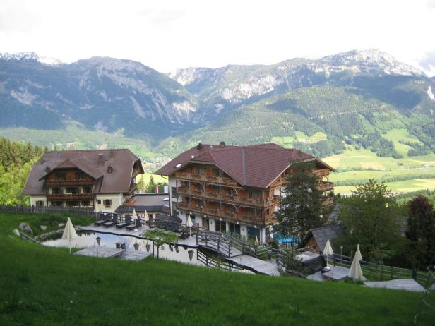 Ein Hotelresort in den Bergen mit Pool und Liegestühlen.