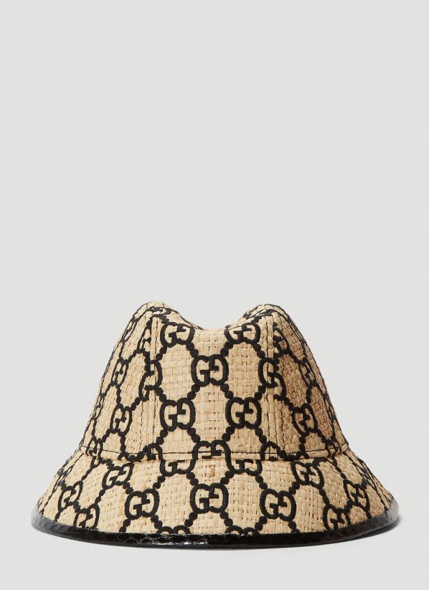 Ein Fischerhut mit schwarzem Gucci-Muster auf beigem Stroh.
