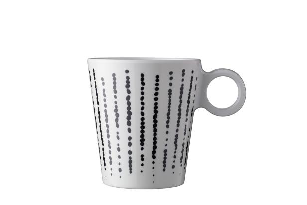 Eine weiße Tasse mit einem Muster aus schwarzen Punkten.