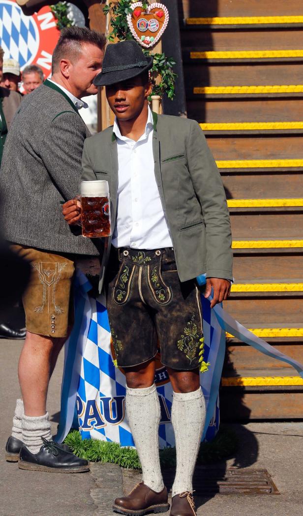 Ein Mann in Tracht hält einen Maßkrug in der Hand.