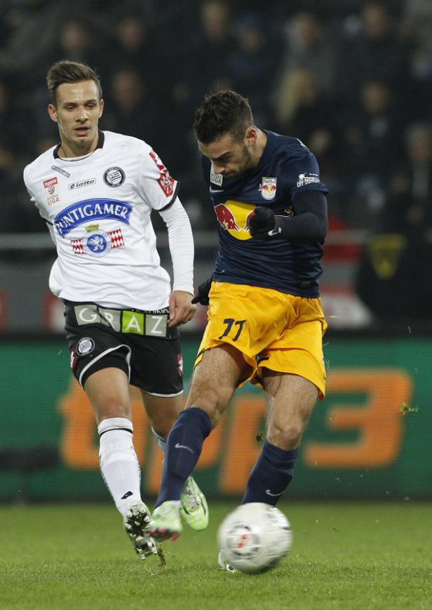 Zwei Fußballspieler kämpfen um den Ball während eines Spiels.