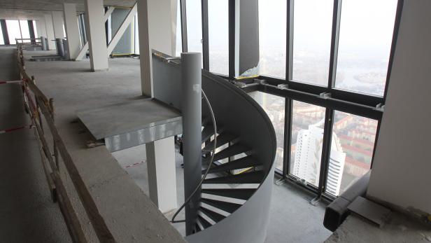 Eine Wendeltreppe in einem Rohbau mit Blick auf die Stadt.