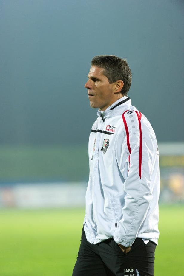 Ein Mann in Sportkleidung steht auf einem Fußballfeld.