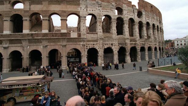 Eine lange Schlange von Menschen wartet vor dem Kolosseum in Rom.