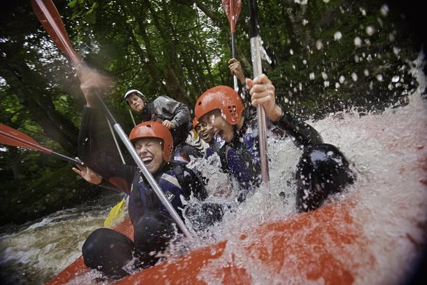 Eine Gruppe von Menschen raftet auf einem wilden Fluss.