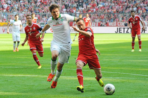 Zwei Fußballspieler kämpfen um den Ball auf dem Spielfeld.