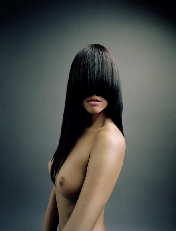 Eine Frau mit langen, dunklen Haaren, die ihr Gesicht bedecken.