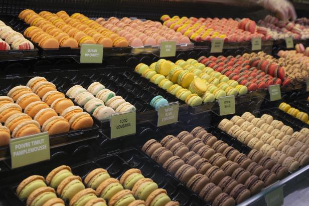 Eine Auslage mit vielen bunten Macarons in verschiedenen Geschmacksrichtungen.