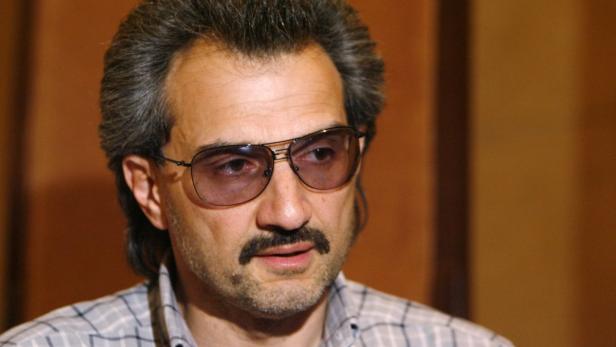 Ein Mann mit Schnurrbart und getönter Brille blickt zur Seite.