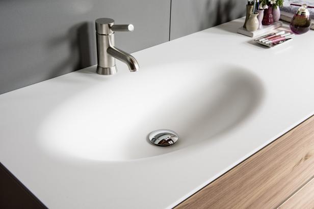 Ein Waschbecken mit Armatur und einigen Kosmetikartikeln auf der Ablage.