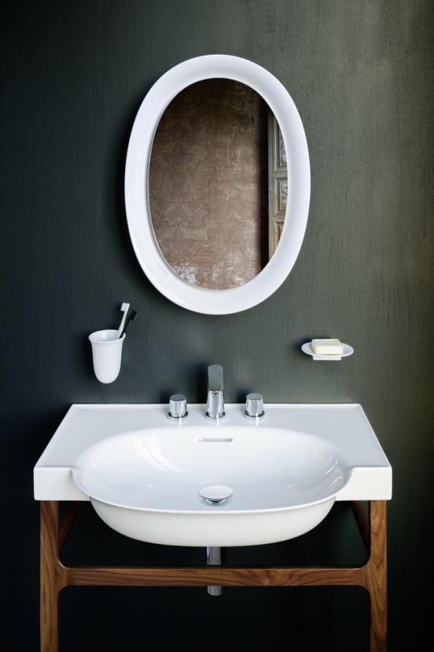 Ein Waschbecken mit Spiegel, Seife und Zahnbürsten in einem modernen Badezimmer.
