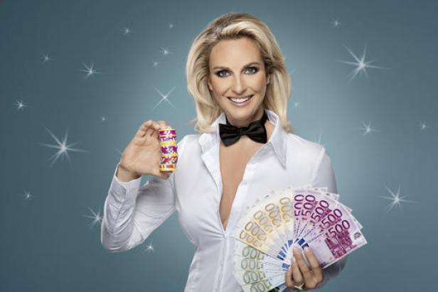 Eine Frau im weißen Hemd und Fliege hält Spielchips und Euro-Scheine in der Hand.