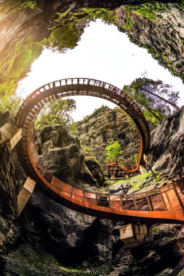 Eine spiralförmige Brücke windet sich durch eine felsige Schlucht.