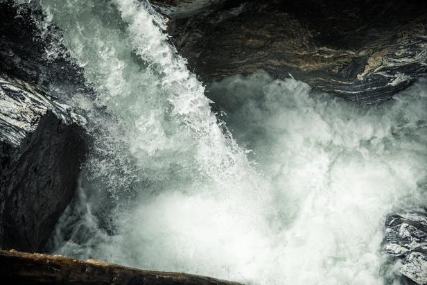 Ein Wasserfall stürzt in ein felsiges Becken.