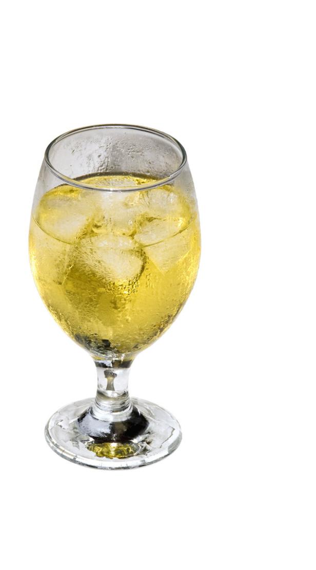 Ein Glas mit einem gelben Getränk und Eiswürfeln.