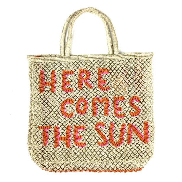 Eine gehäkelte Tasche mit der Aufschrift „Here Comes The Sun“.